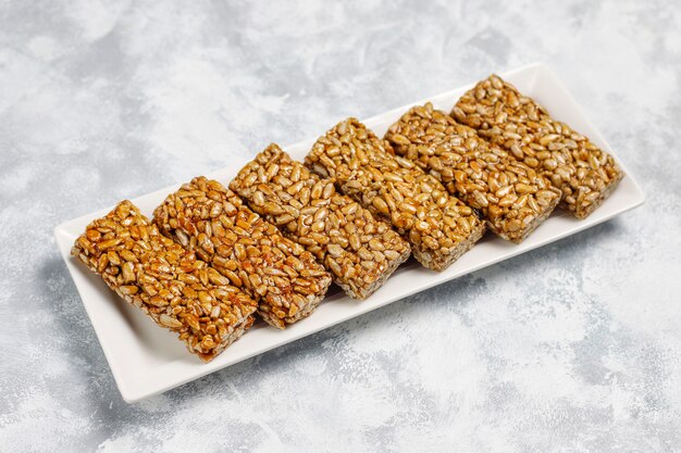 Granola bar. Healthy sweet dessert snack. Sesame, peanut, sunflower in honey. Gozinaki is Georgian national food, oriental sweet. Top view on concrete 