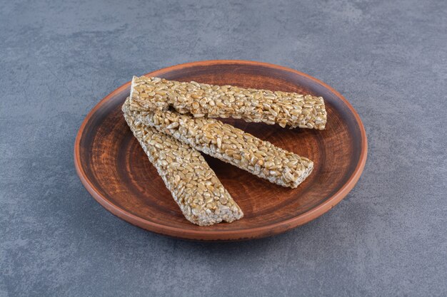 Granola bars in a wooden plate , on the marble surface