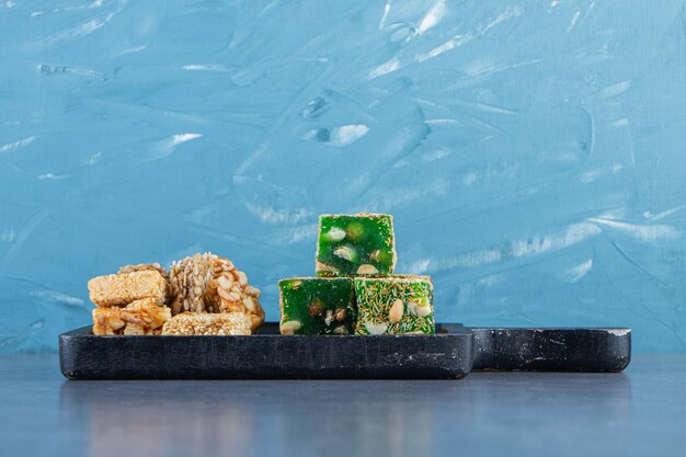 Granola and Turkish delights on a board on the marble surface