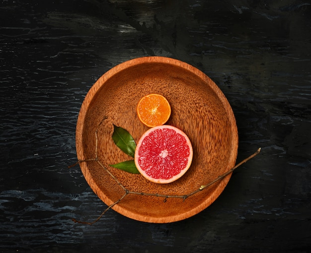 Free photo grapefruit citrus fruit halves on wooden plate