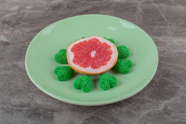 Grapefruit and cookie on the plate on the marble surface