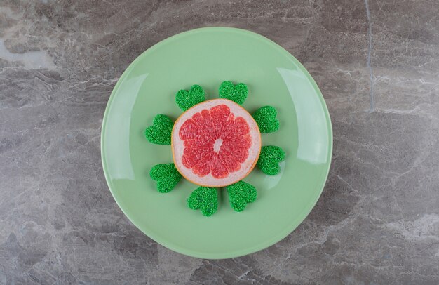 Grapefruit and cookie on the plate on the marble surface