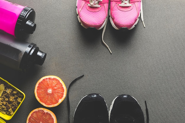 Grapefruit near sneakers and bottles