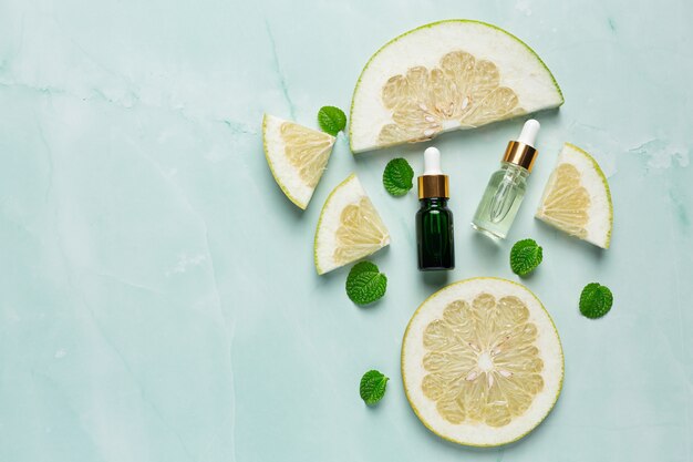 Grapefruit oil serum bottle put on green light background