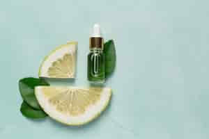 Free photo grapefruit oil serum bottle put on green light background