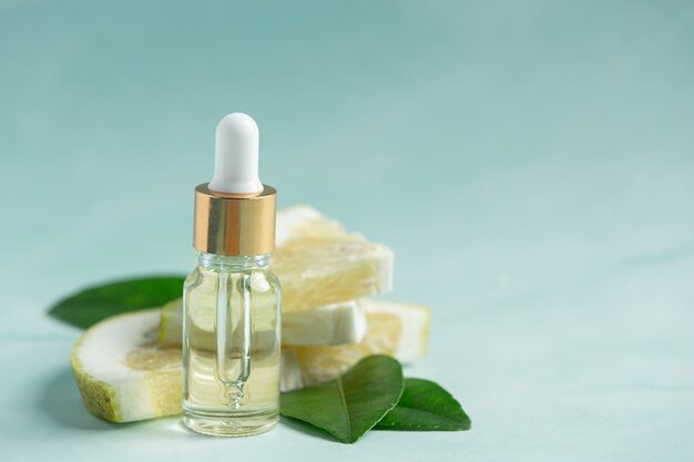 Grapefruit oil serum bottle put on green light background