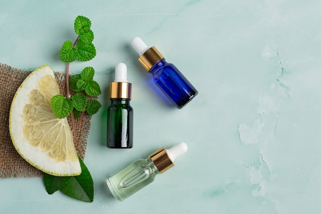 Foto gratuita bottiglia di siero olio di pompelmo messa su sfondo verde chiaro