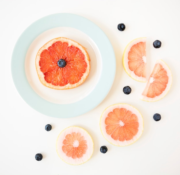Free Photo | Grapefruit slice with blueberries isolated on white background
