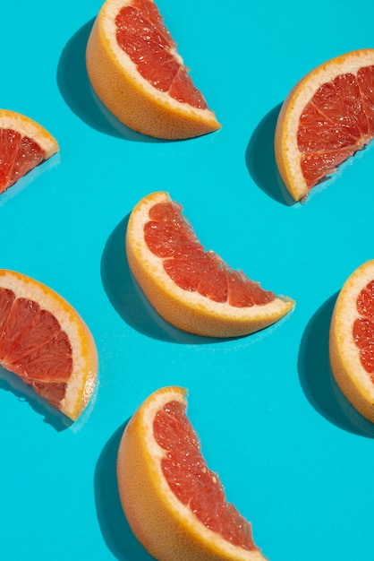 Grapefruit slices on blue background top view
