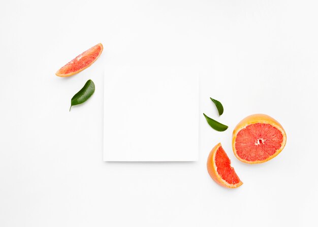 Grapefruit and slices with leaves isolated on white surface