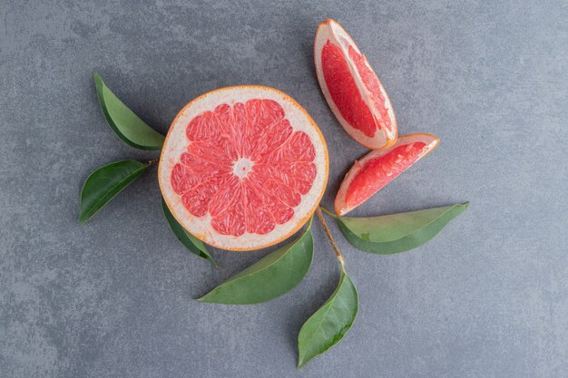 Grapefruits and leaves on a gray surface