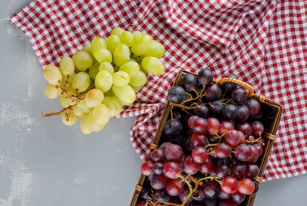 Grapes in a basket on picnic cloth and plaster.