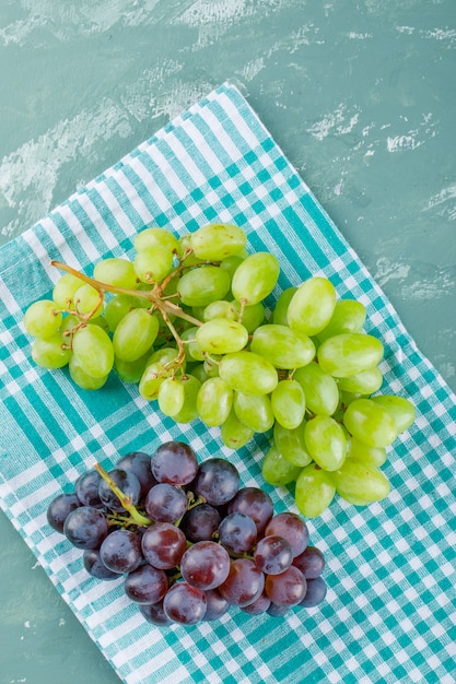 Grapes top view on plaster and picnic cloth background