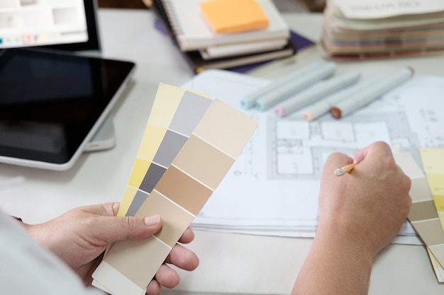 Graphic design and color swatches and pens on a desk. Architectural drawing with work tools and accessories.