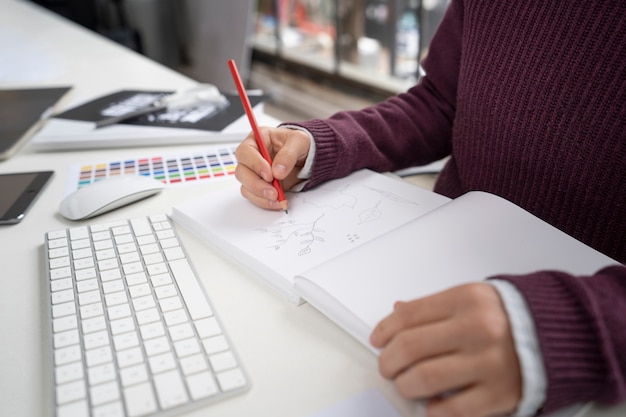 Graphic designer making a logo on a notebook