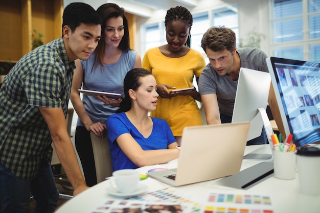 Graphic designers discussing over laptop