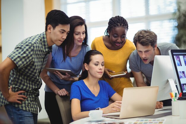 Graphic designers discussing over laptop