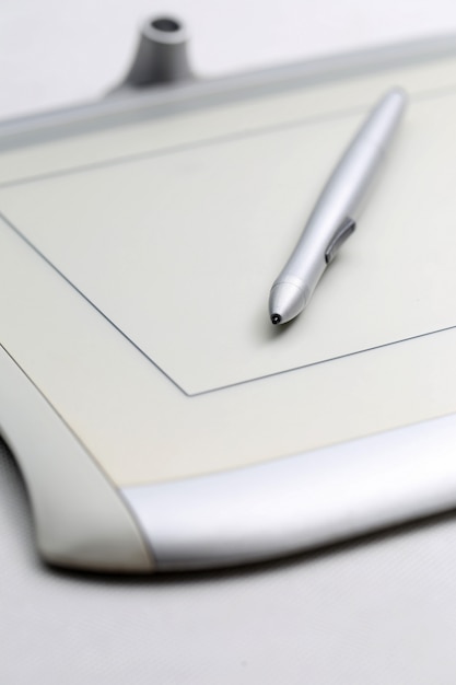 Графический планшет и ручка, чувствительная к давлению на белом фоне