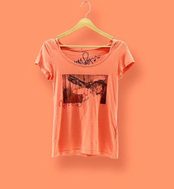 Графическая футболка Trendy Design Mockup представлена на деревянной вешалке