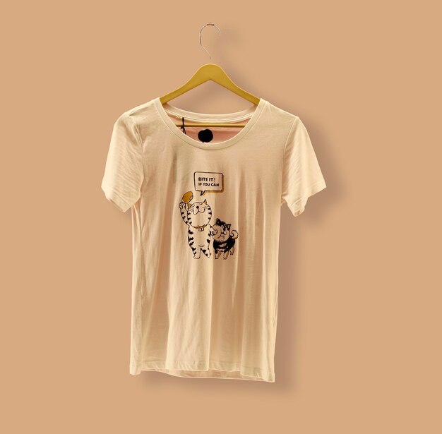 Графическая футболка Trendy Design Mockup представлена на деревянной вешалке