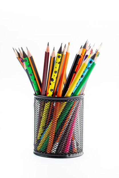 Яркие графитные карандаши на подкладке внутри черной корзины на белом столе