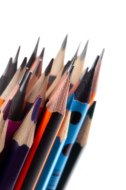 Graphite pencils for writing and drawing along with multicolored pencils lined on white desk