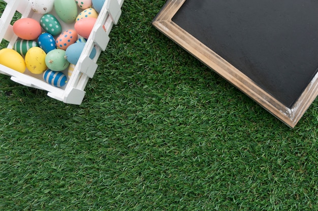 Grass background with blank slate and easter eggs