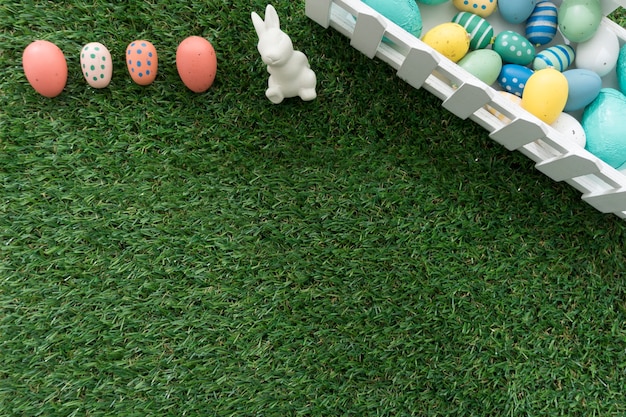 Grass background with colored eggs and easter bunny