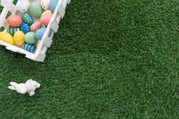 Grass background with easter bunny and colored eggs