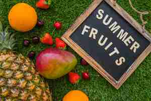 Free photo grass surface with decorative slate and summer fruits