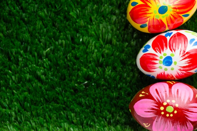Free photo grass surface with three colorful easter eggs