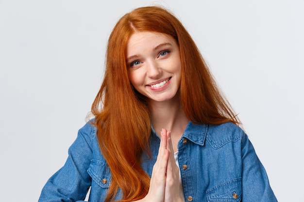 Grateful charming, lovely redhead woman appreciate help, thanking and bowing politely with namaste gesture, hold hands together over chest pray sign, smiling pleased, white background.