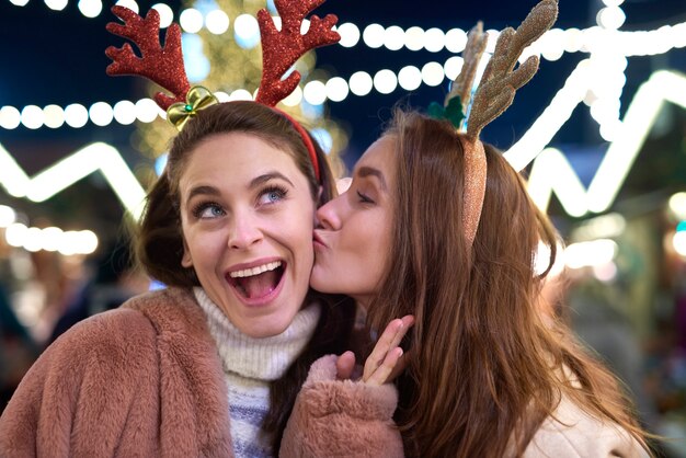 Grateful woman giving a kiss on Christmas market