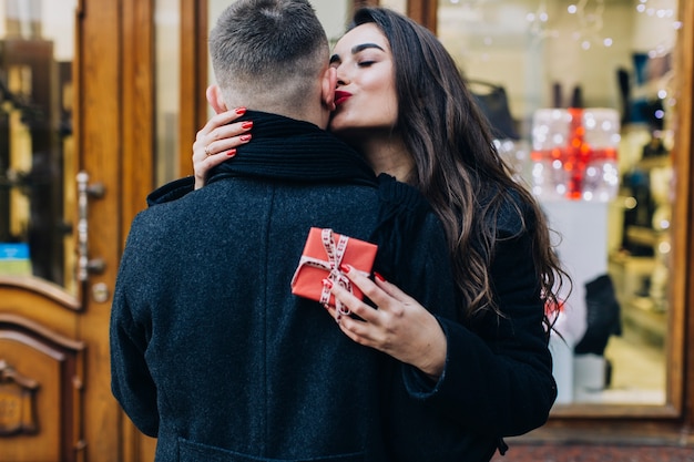 Grateful woman kissing man for present