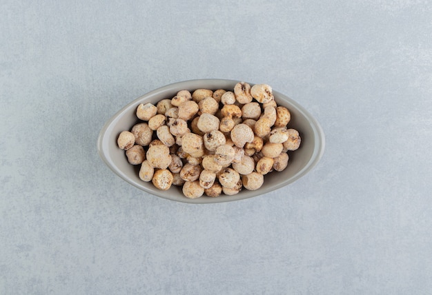 A gray bowl full of delicious round food . 