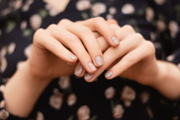 Gray nail design. Female hand with glitter manicure.