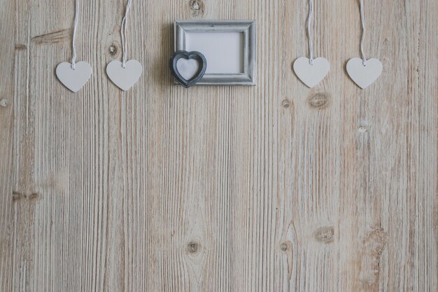 Gray photo frame and hearts hanging on ropes