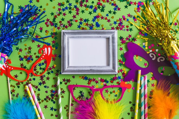 Gray photo frame with confetti on a green background and colorful glasses