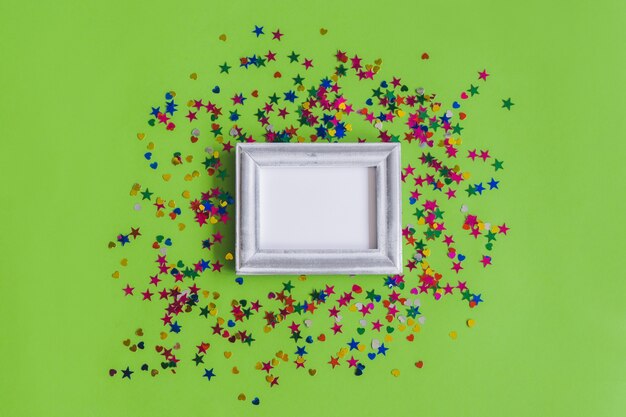Gray photo frame with confetti on a green background