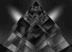 Free photo gray scale low angle shot of a pyramid shaped glass building