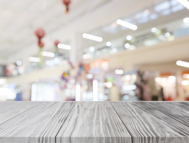 Gray wooden desk in front of illuminated shopping center