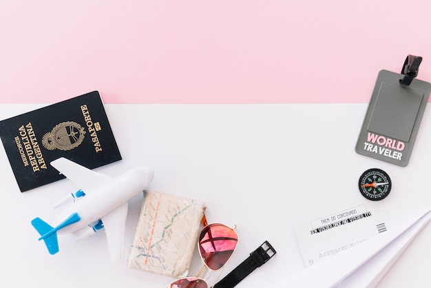 여권으로 회색 세계 여행자 태그; 지도; 나침반; 티켓; 장난감 비행기; 선글라스와 듀얼 배경에 손목 시계