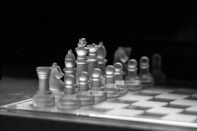 Grayscale shot of a glass chessboard