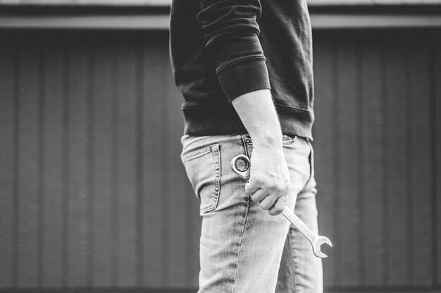 Grayscale shot of a technician holding a tool