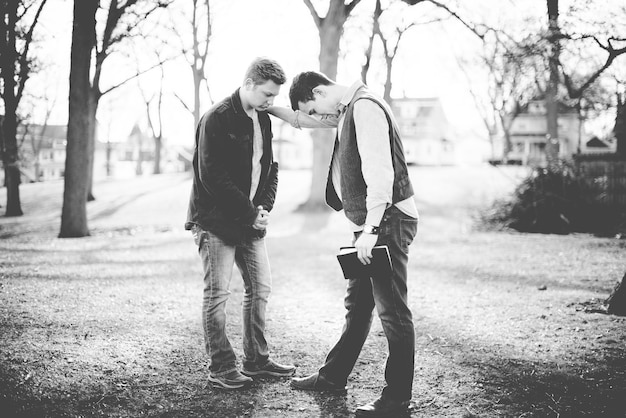 Free photo a grayscale shot of two males praying together