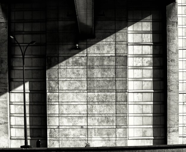 Grayscale symmetric shot of a stone shadowed wall - depression, solitude concept