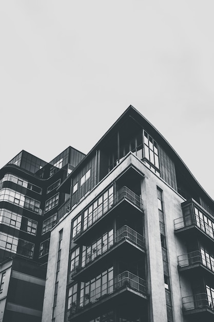 Foto gratuita colpo verticale di gradazione di grigio di edifici architettonici con i balconi