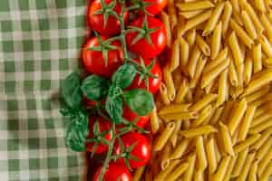 Foto gratuita grande composizione con maccheroni, pomodori, e tovaglia