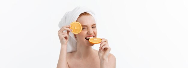 건강한 라이프스타일을 위한 훌륭한 음식 오렌지 서 있는 조각을 들고 있는 아름다운 젊은 벗은 여자