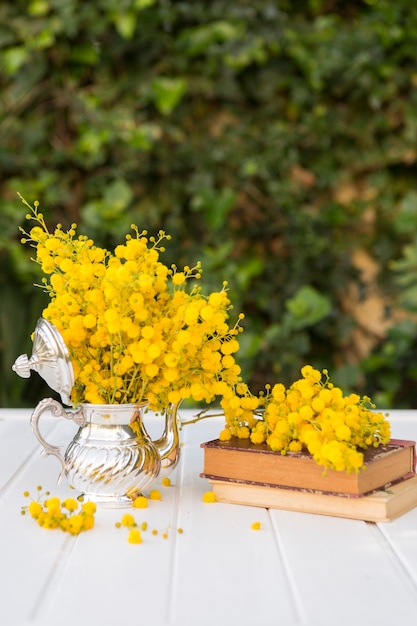 Отличная сцена из желтых цветов, чайника и книг